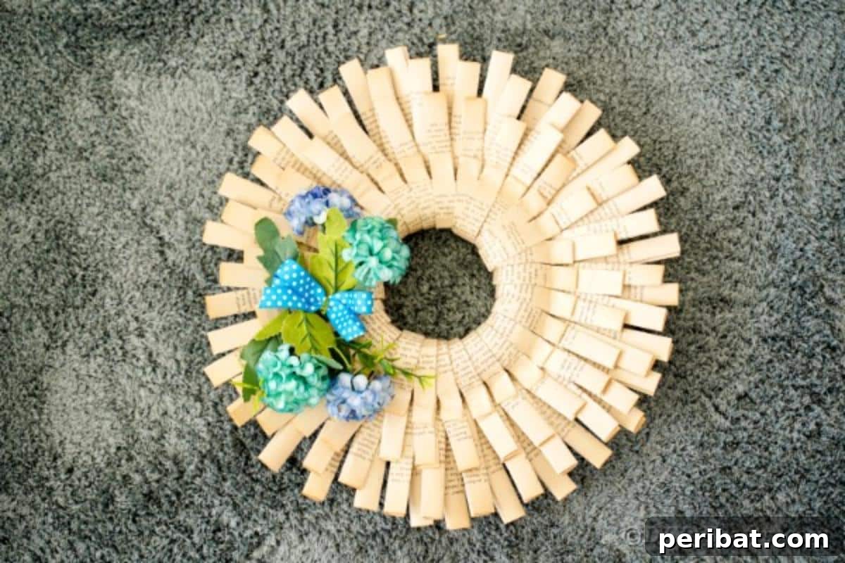 A meticulously folded book page paper wreath rests gently on a plush carpet, showcasing its delicate construction and design.