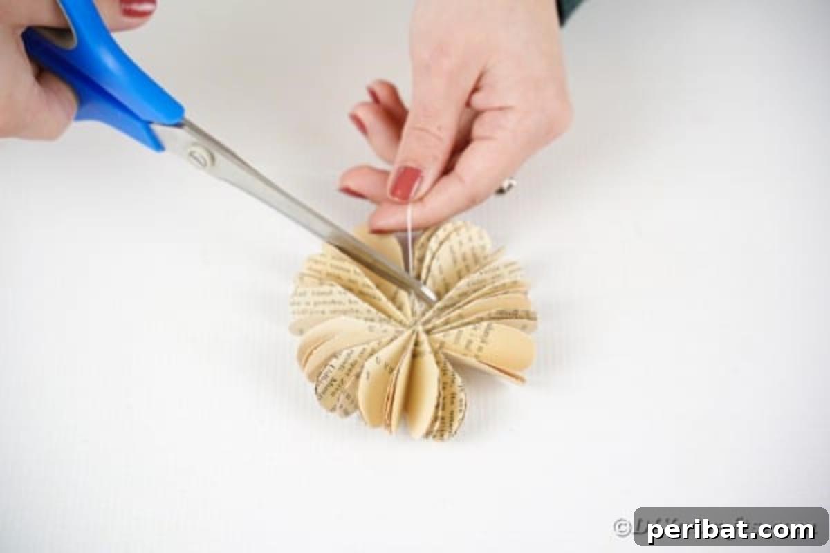 Charming Blooms from Repurposed Book Pages 18 Cutting the thread off a finished paper flower after tying a knot to secure its shape