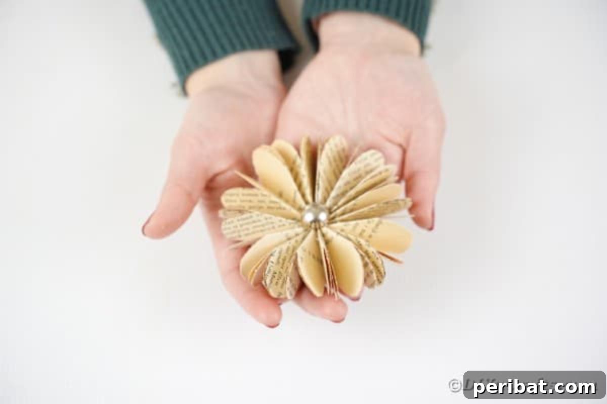 Charming Blooms from Repurposed Book Pages 20 Woman holding an old book page paper flower, ready for display or use