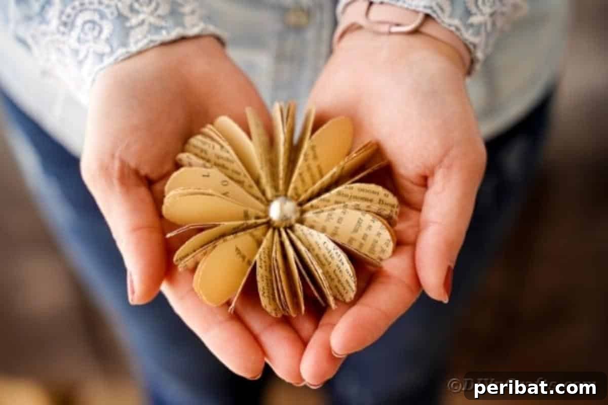 Charming Blooms from Repurposed Book Pages 5 A person gently holding a finished paper flower made from old book pages, demonstrating its delicate beauty