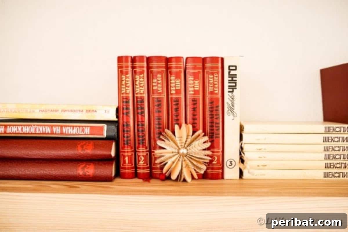 Charming Blooms from Repurposed Book Pages 6 A delicate paper flower made from old book pages sits in front of a small stack of books, emphasizing its origin