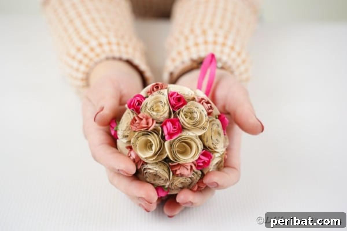 From Pages to Petals: DIY Book Rose Sphere 17 A woman proudly displays her finished paper rose ball, ready to adorn her home decor