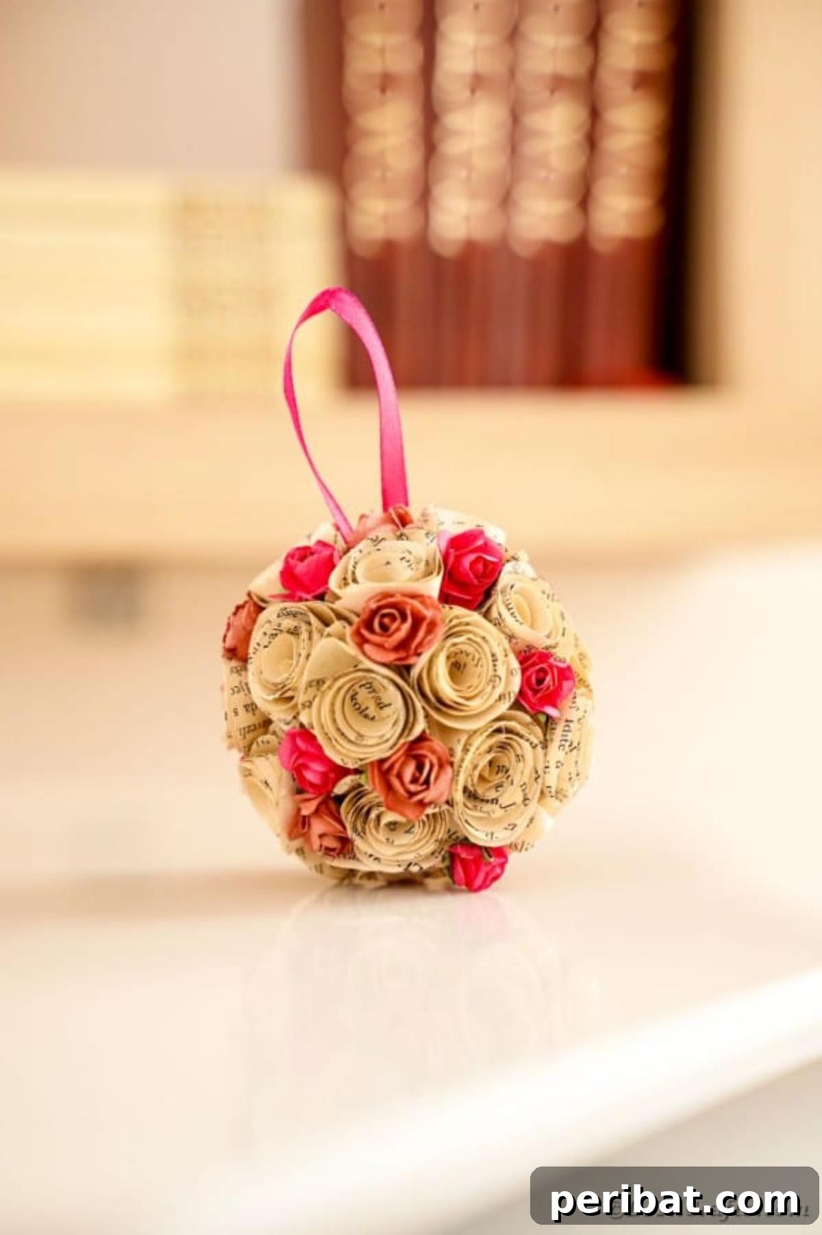 From Pages to Petals: DIY Book Rose Sphere 21 A charming rose paper ball decoratively placed on a table in front of a collection of old books