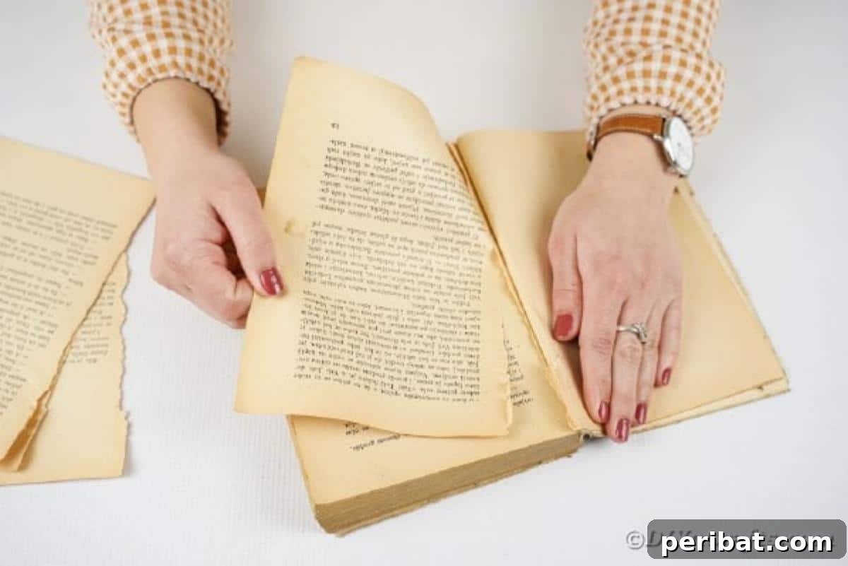 From Pages to Petals: DIY Book Rose Sphere 8 Hands carefully tearing pages from an old book, preparing them for the craft project