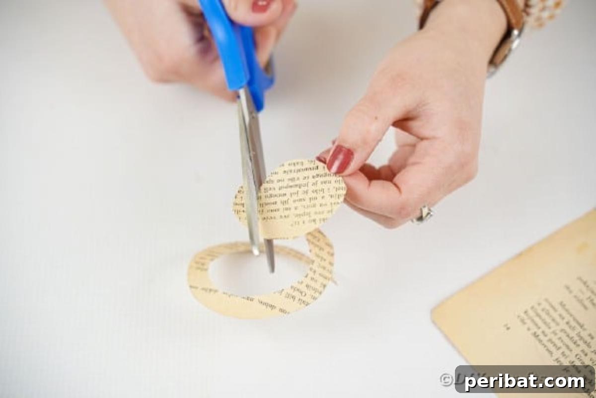 From Pages to Petals: DIY Book Rose Sphere 9 A hand demonstrates cutting a spiral pattern from a paper circle, a key step in forming a rose