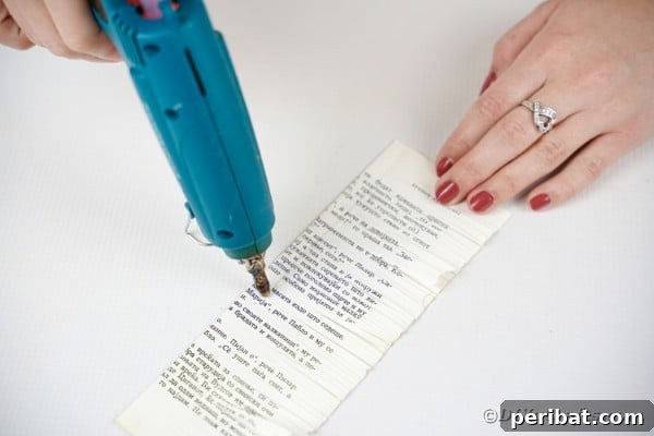 Gluing the fringed paper into a tight roll to form a flower