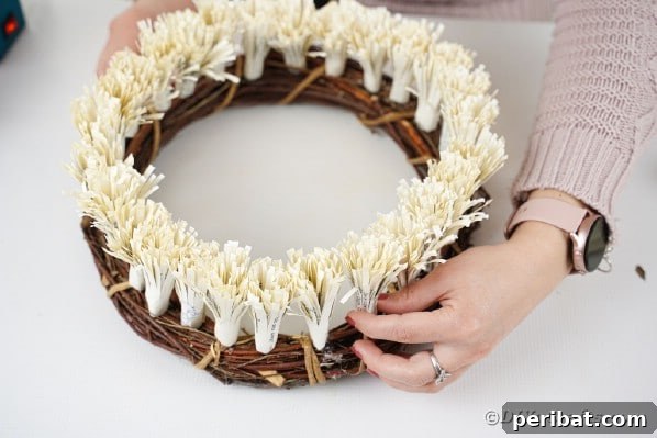Gluing frigned paper flowers to grapevine wreath