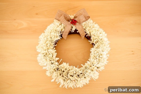 Old book page wreath against blonde wood background, highlighting its vintage appeal