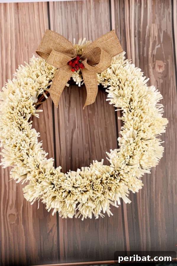 Another view of the paper fringed wreath on a rustic wooden surface
