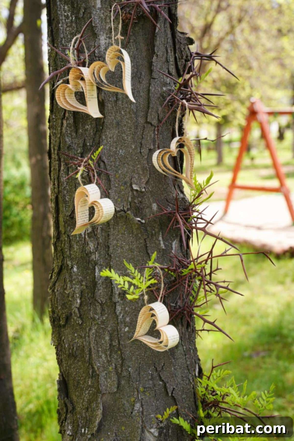 Heirloom Book Page Heart Bunting 4 Delicate paper heart banner hanging gracefully on a tree branch outdoors