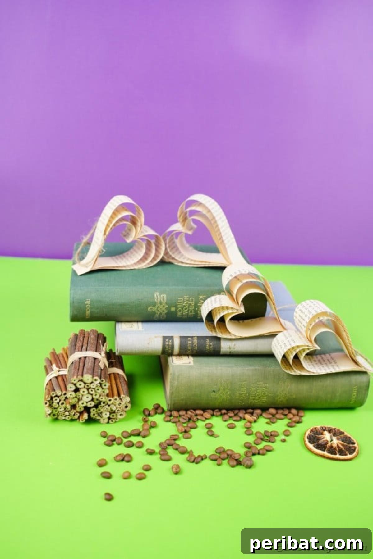 Heirloom Book Page Heart Bunting 20 Several paper hearts from book pages arranged on a stack of vintage books on a green table