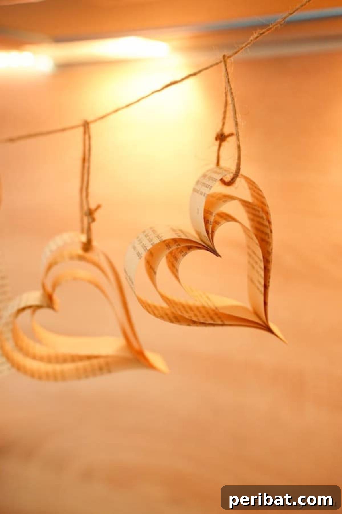 Heirloom Book Page Heart Bunting 24 A beautiful paper heart banner made from old book pages hanging against a blonde wood background