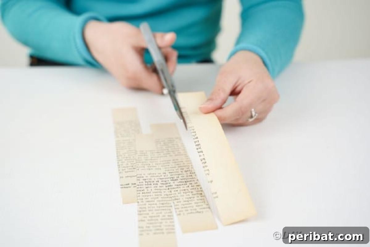 Heirloom Book Page Heart Bunting 9 Hands carefully cutting an old book page into narrow strips using scissors
