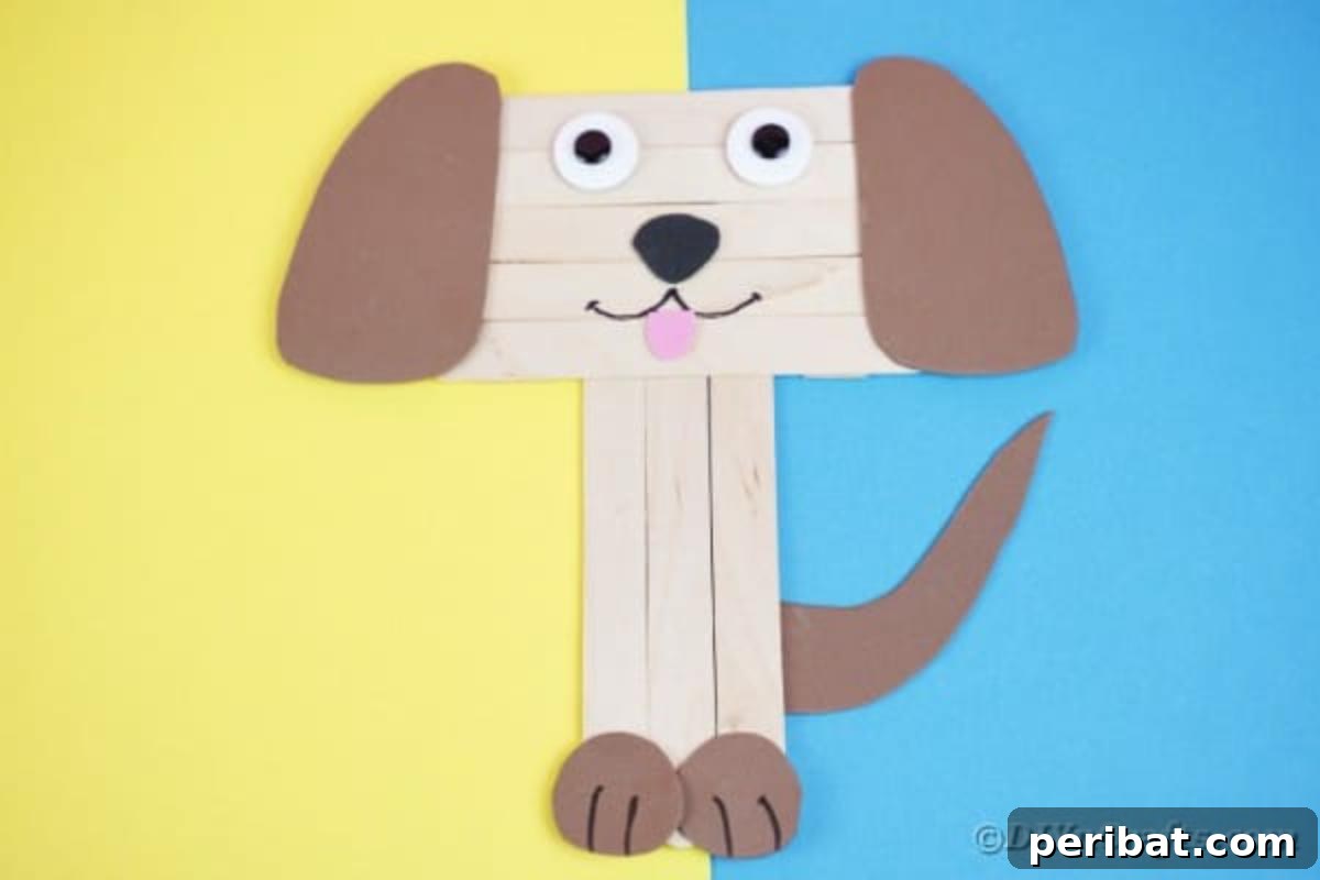 Smiling craft stick puppy on colorful blue and yellow paper
