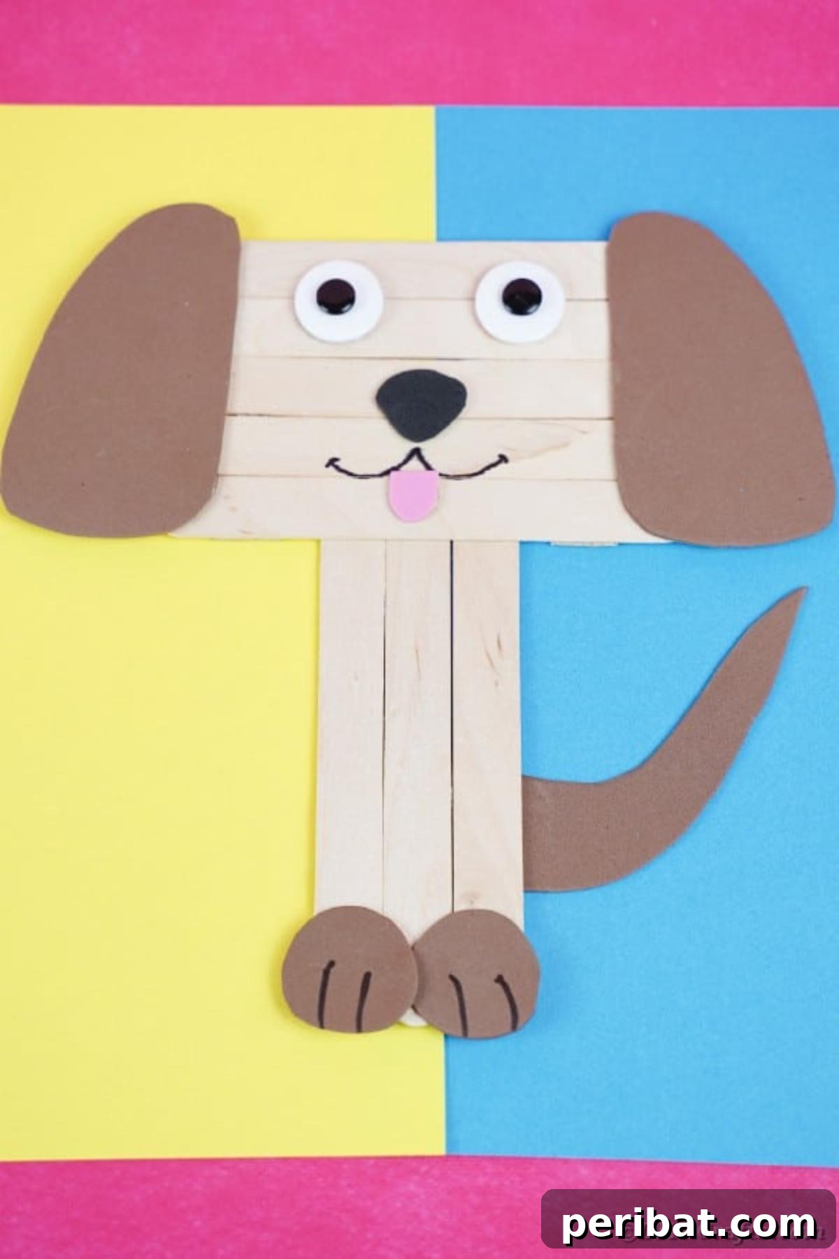 A craft stick puppy with a blue body and yellow details on a matching background