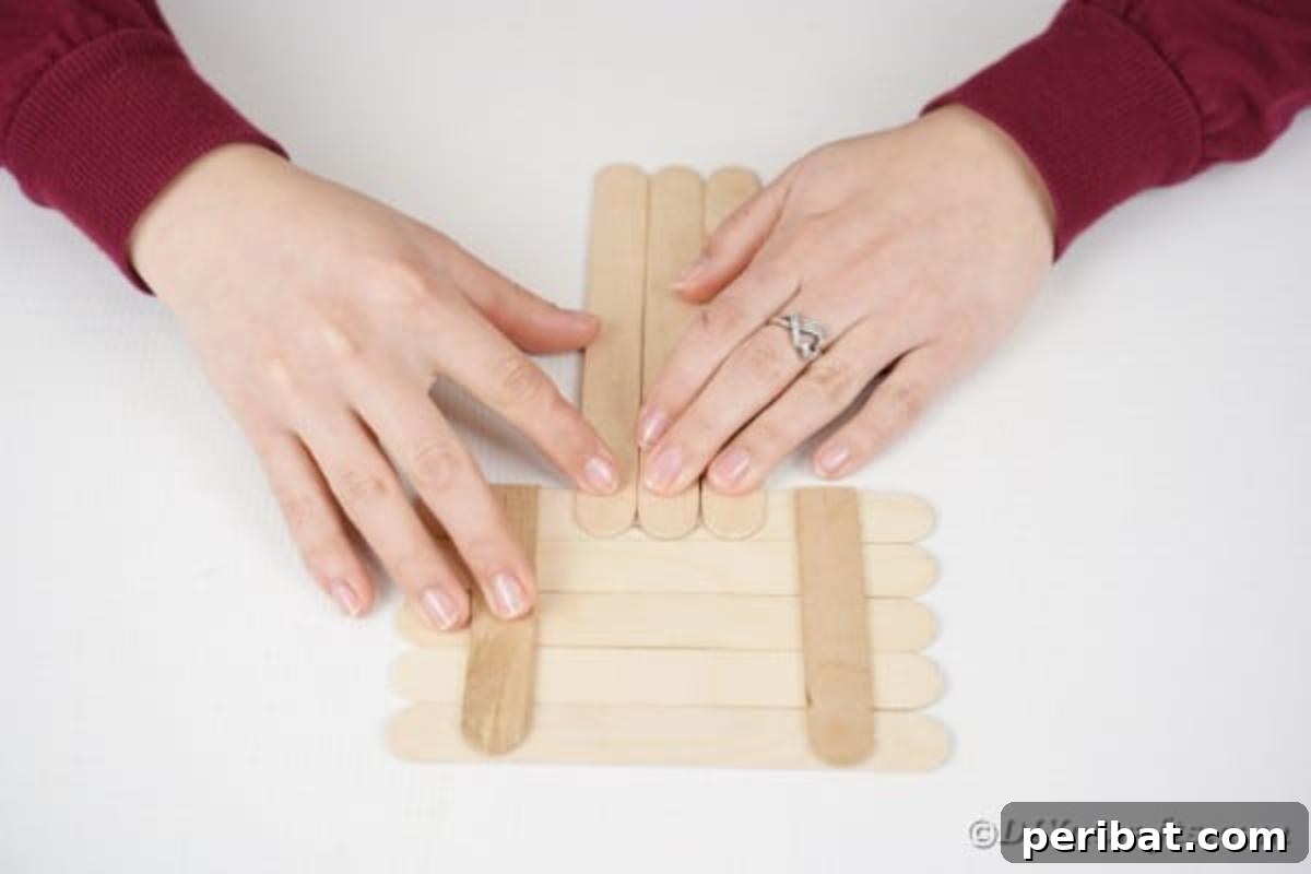 Gluing three craft sticks vertically to form the puppy's legs