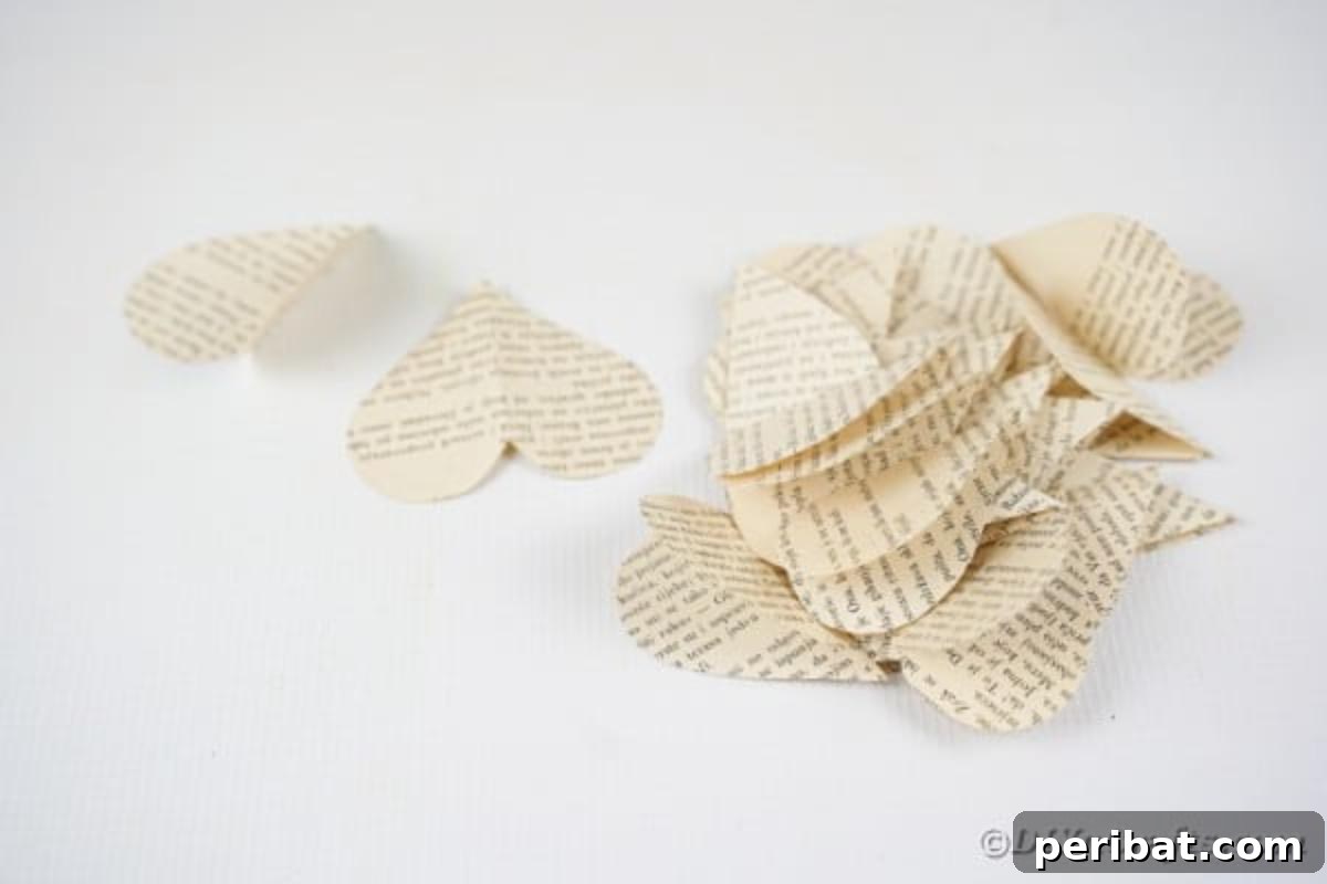 A neat stack of folded paper hearts, prepared for assembling into a garland