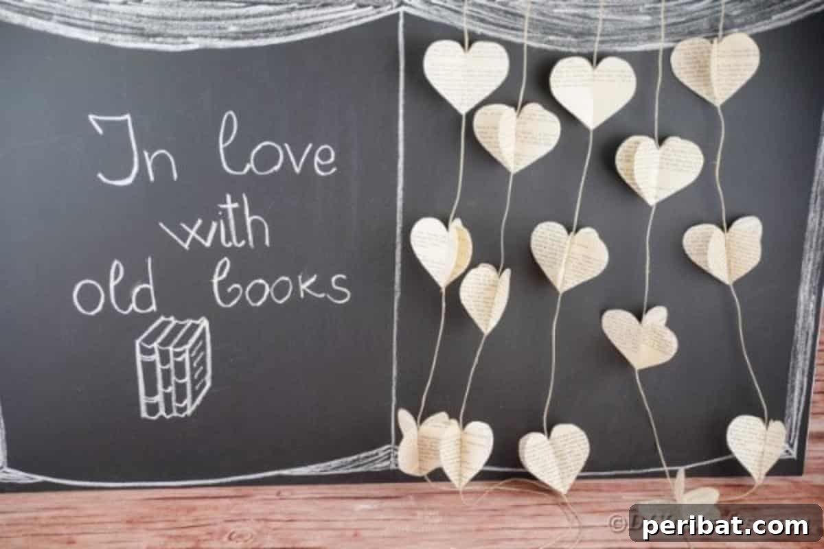 Handmade paper heart garland from vintage book pages, displayed against a dark chalk wall, highlighting its country chic charm