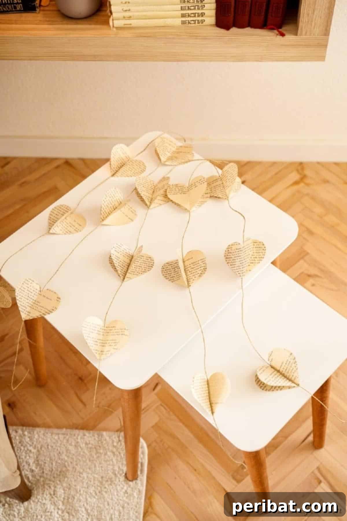 Heart garland made from old book pages, artfully arranged on a weathered end table, contributing to a cozy country chic aesthetic