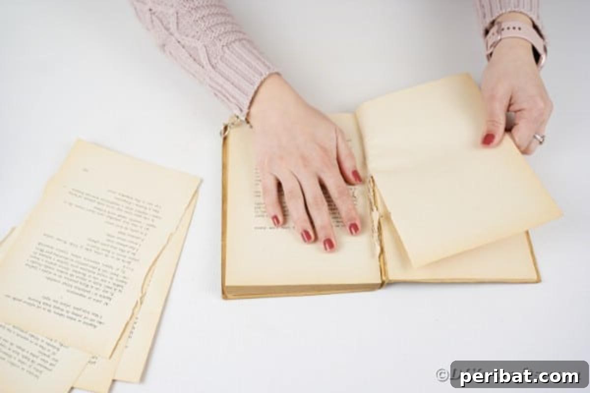 Tearing pages from an old book to prepare for crafting paper hearts