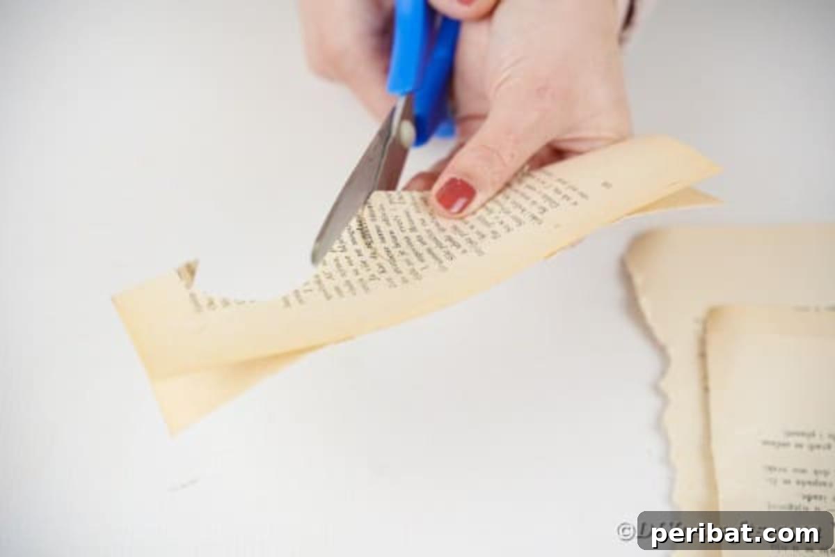 Cutting heart shapes out of old book pages after folding them in half