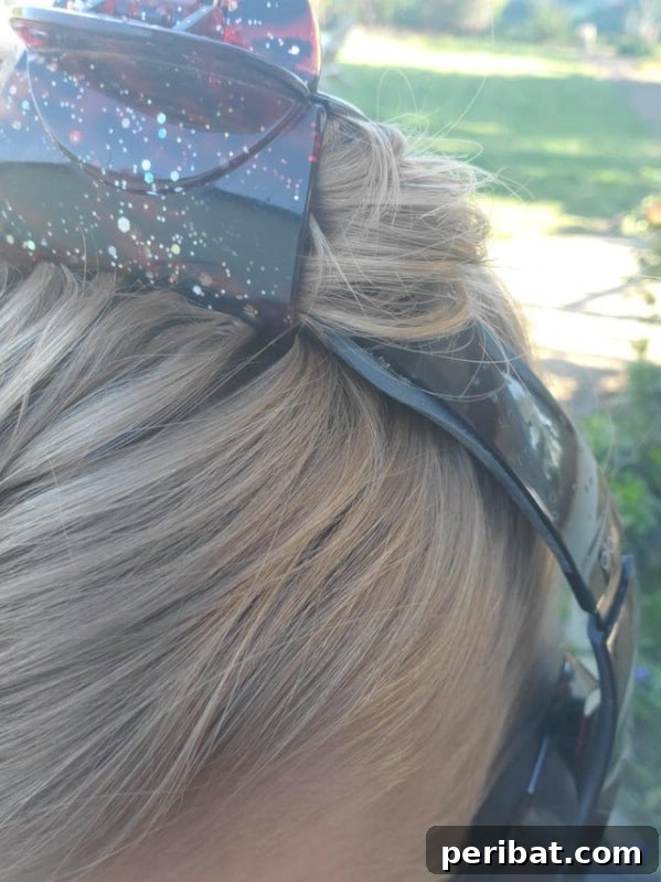 Hair clip holding headphones on head - A hair clip securing headphone wires to a person's head