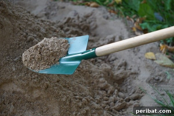 Digging up sand - A shovel digging into a patch of sand unexpectedly found underground
