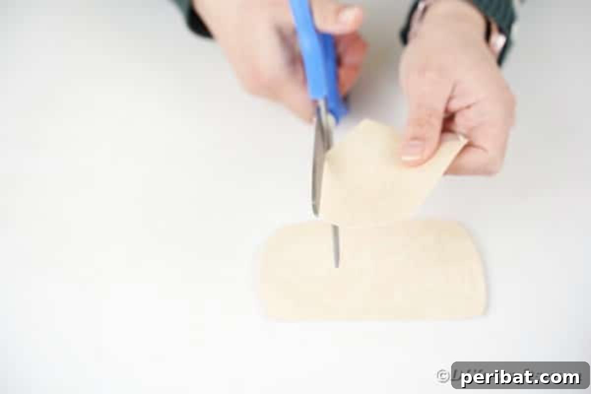 Cutting face for santa from book page, showing the face outline being cut