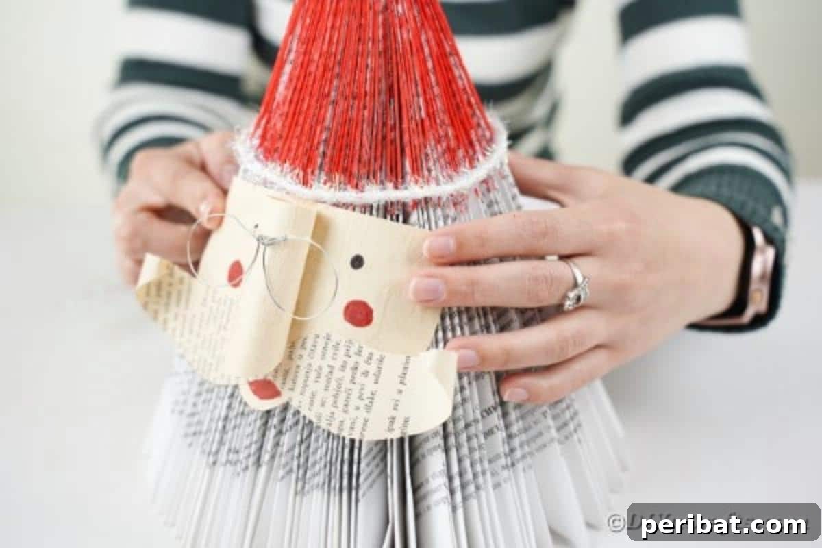 Gluing Santa face onto book, showing the final assembly of the Santa figure