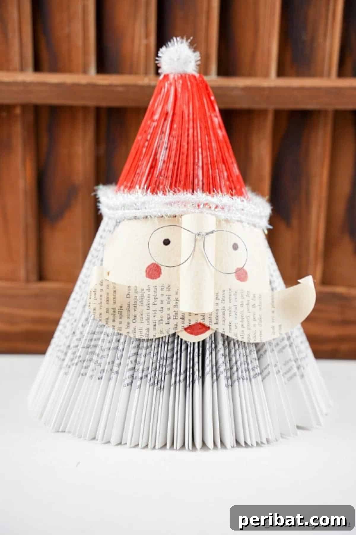 Book Santa Claus in front of wooden slats, highlighting the painted hat
