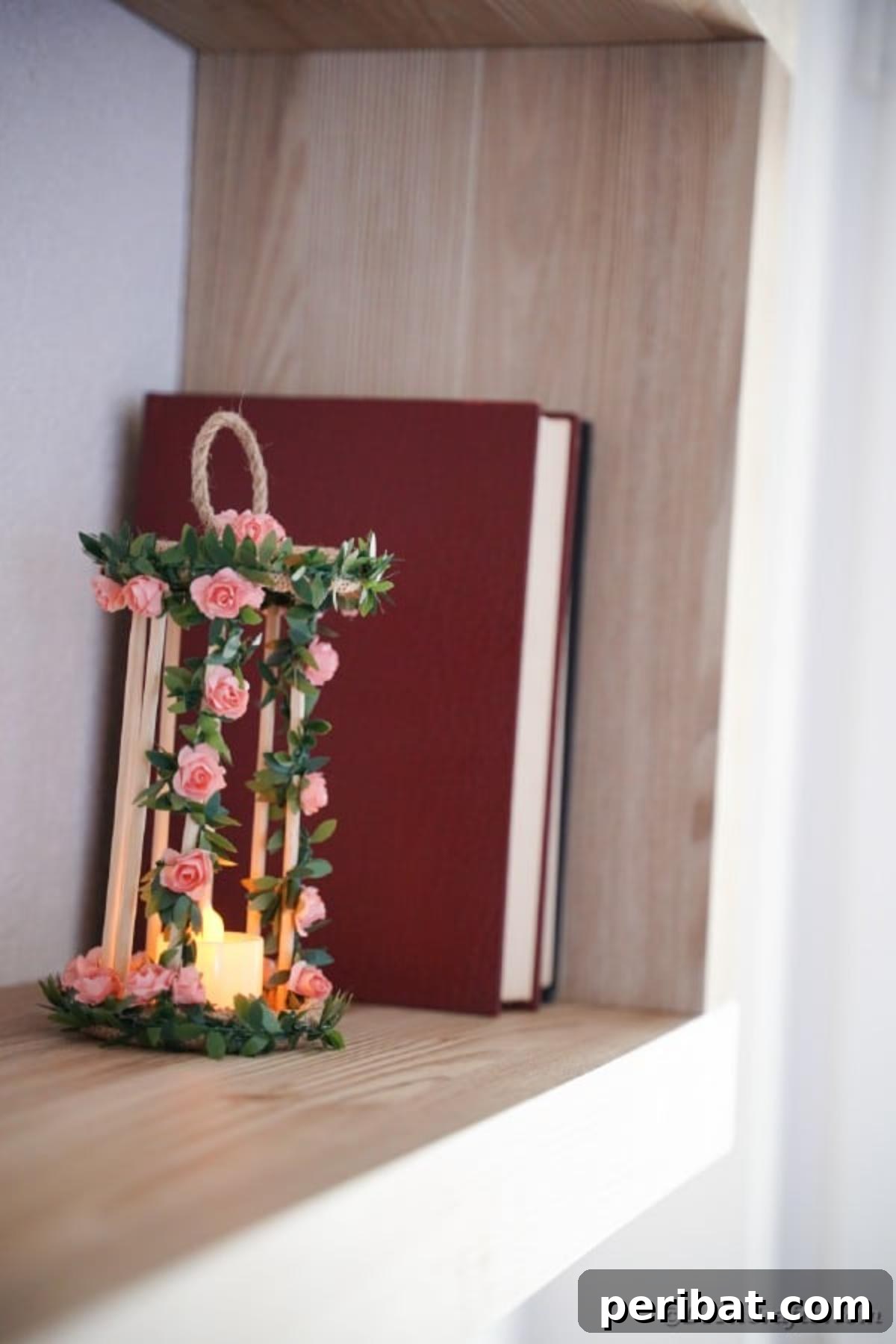 Enchanted Garden Birdcage Luminary 21 Birdcage candle holder styled on a wooden shelf next to books and other decorative items.