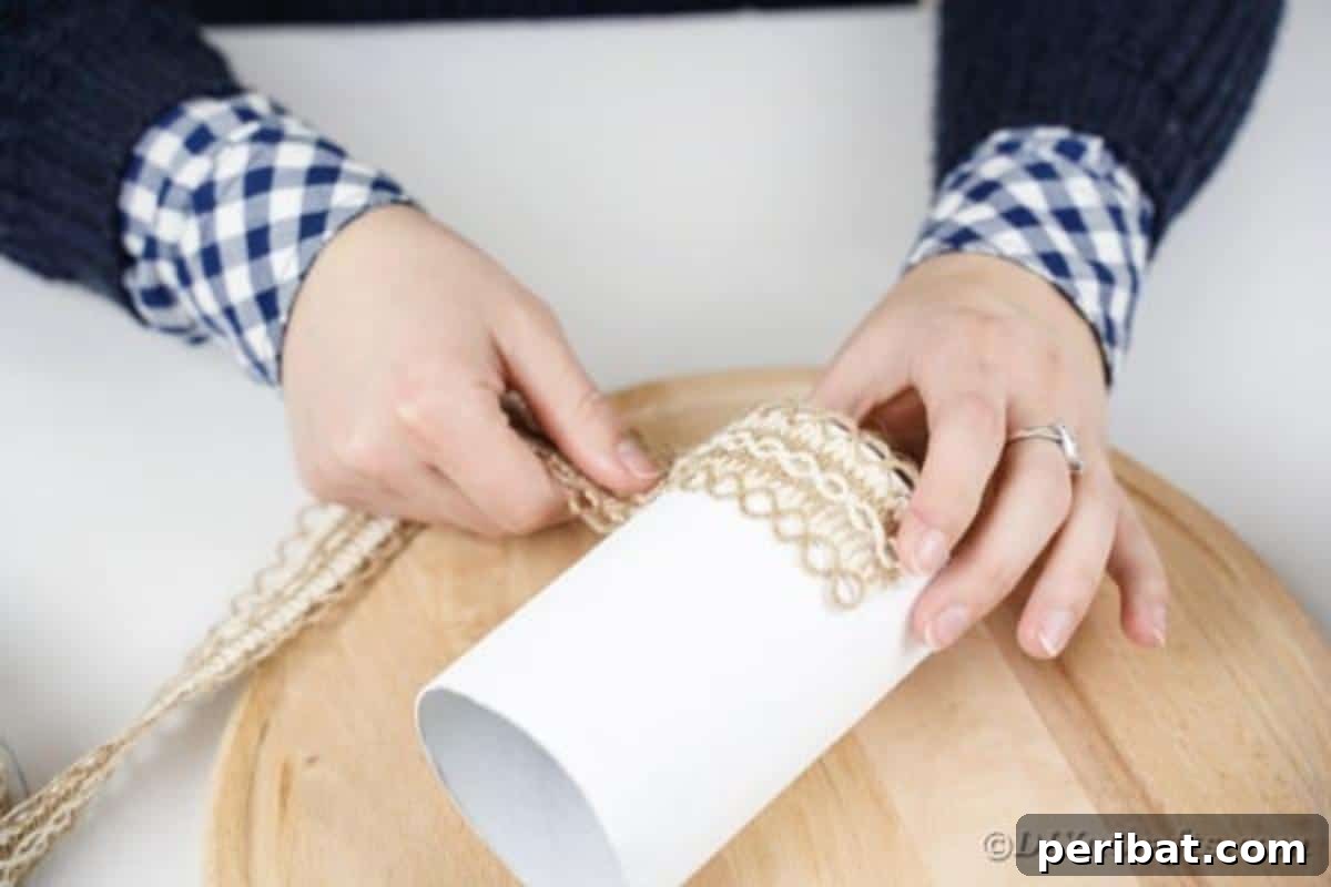 Farmhouse Storage from Repurposed Pringles Cans 12 Burlap lace being glued around the bottom edge of a white Pringles can