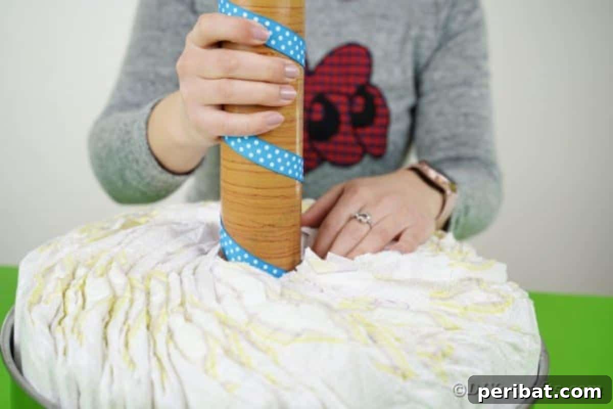 Whimsical Animal Carousel Diaper Cake 11 Carefully inserting the wrapped cardboard tube into the center of the diaper arrangement