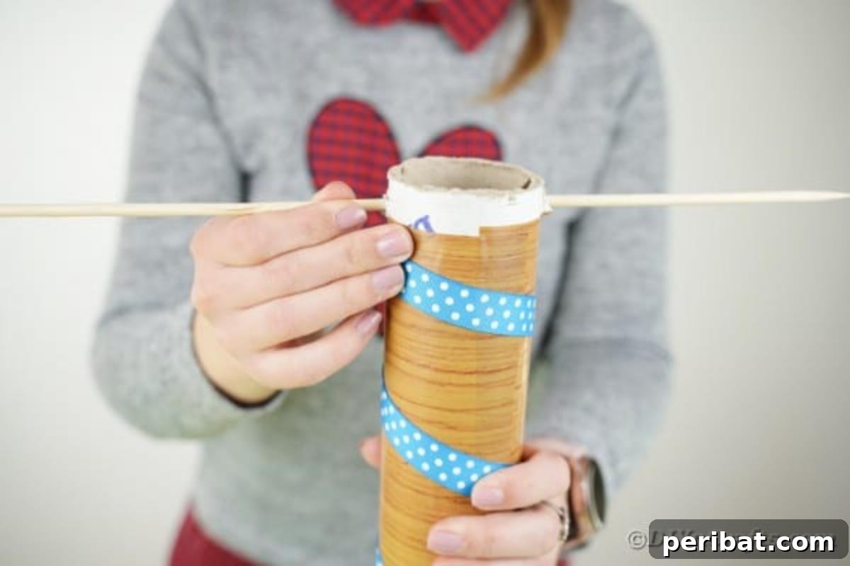 Whimsical Animal Carousel Diaper Cake 14 Inserting a wooden skewer through the top of the cardboard tube to support the carousel roof