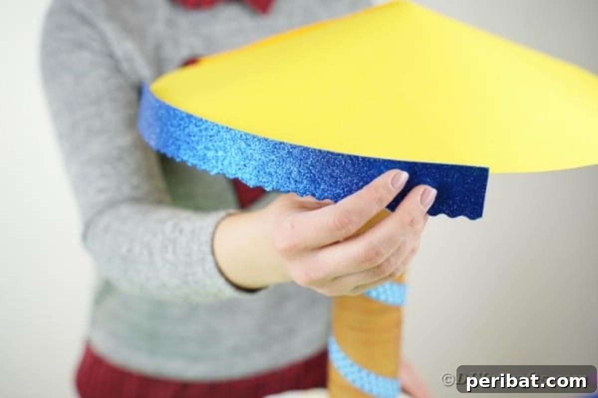 Whimsical Animal Carousel Diaper Cake 17 Adding decorative blue glitter foam trim to the bottom edge of the yellow carousel roof