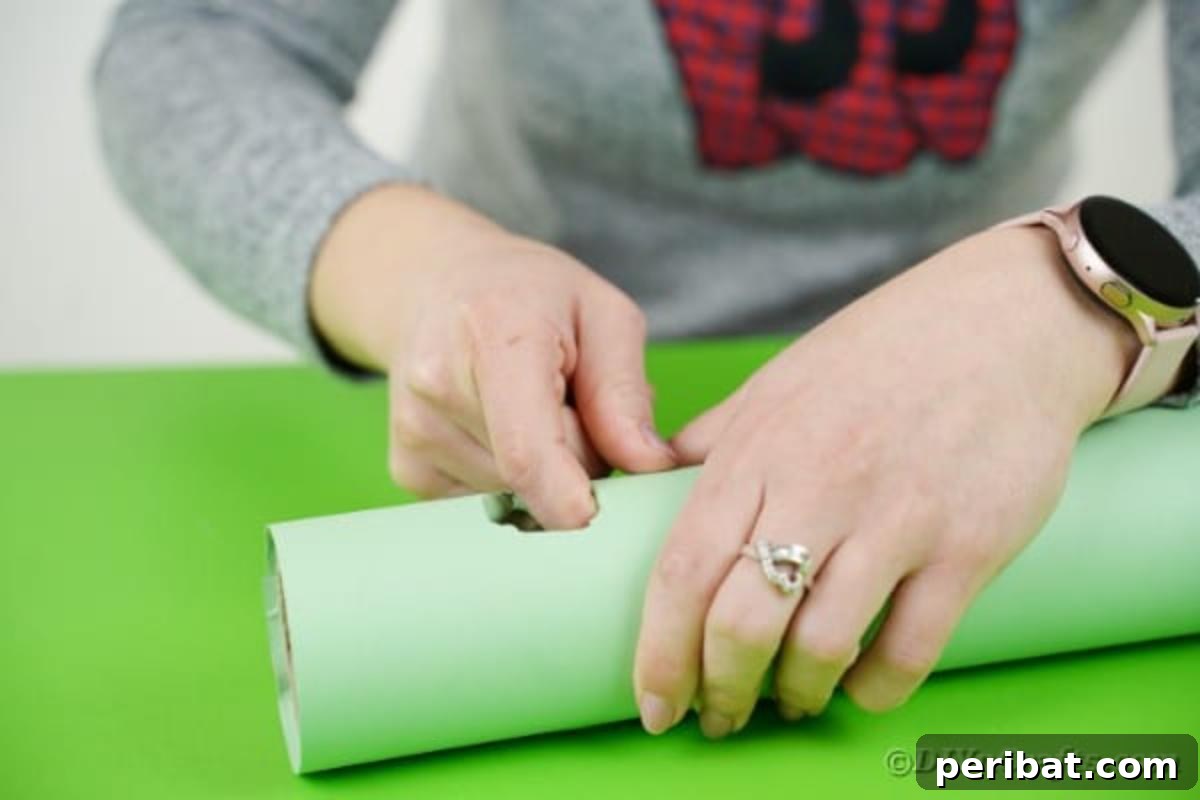 Detail shot of wrapping paper being neatly folded and tucked into the cut-out hole of a cardboard tube, secured with tape to create a clean opening.