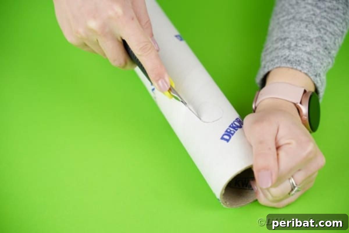 A utility knife meticulously cutting out a circular hole in a cardboard tube, demonstrating the precision needed for the crane's movable parts.