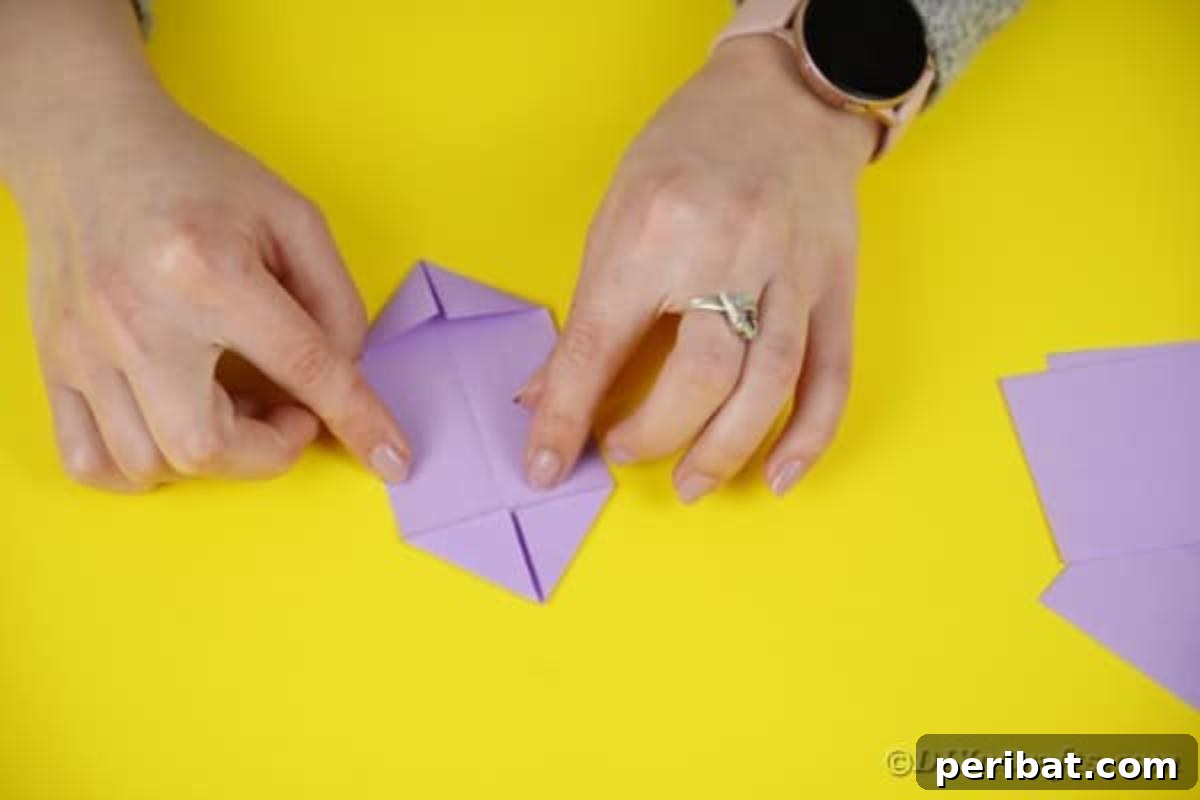 Initial fold of purple paper, forming a central crease.