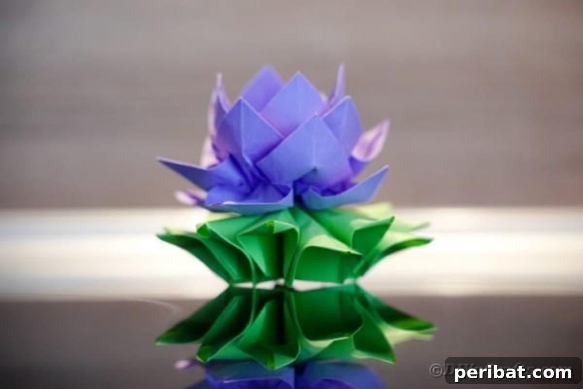 Close-up of a vibrant purple paper lotus on a black background, showcasing its symmetrical design.
