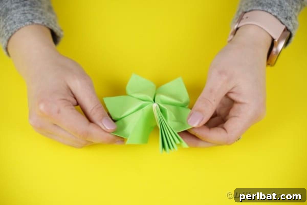 Green paper segments fully unfolded and separated to form a complete leaf base.