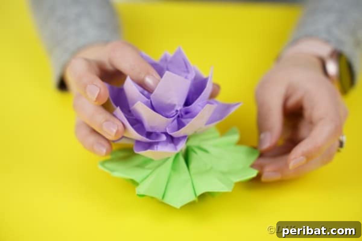 Purple paper lotus being glued onto the green leaf base.