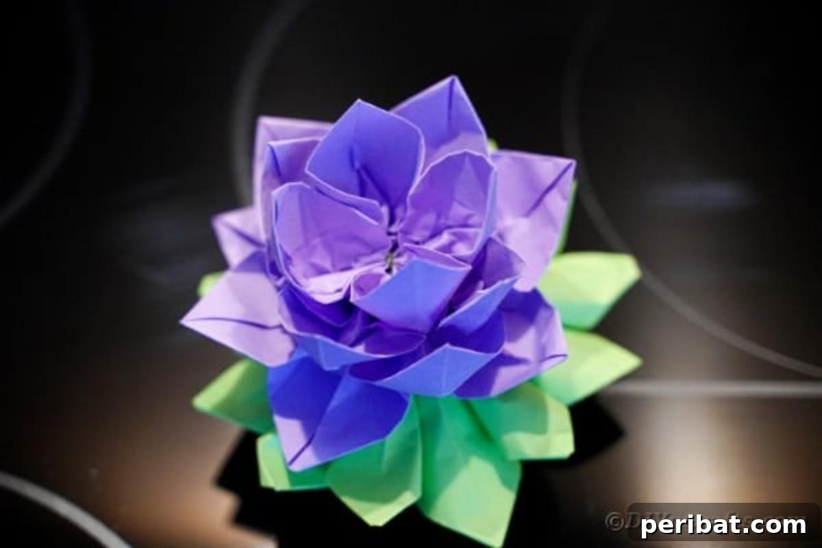 Finished purple paper lotus decoration placed on a sleek black table.