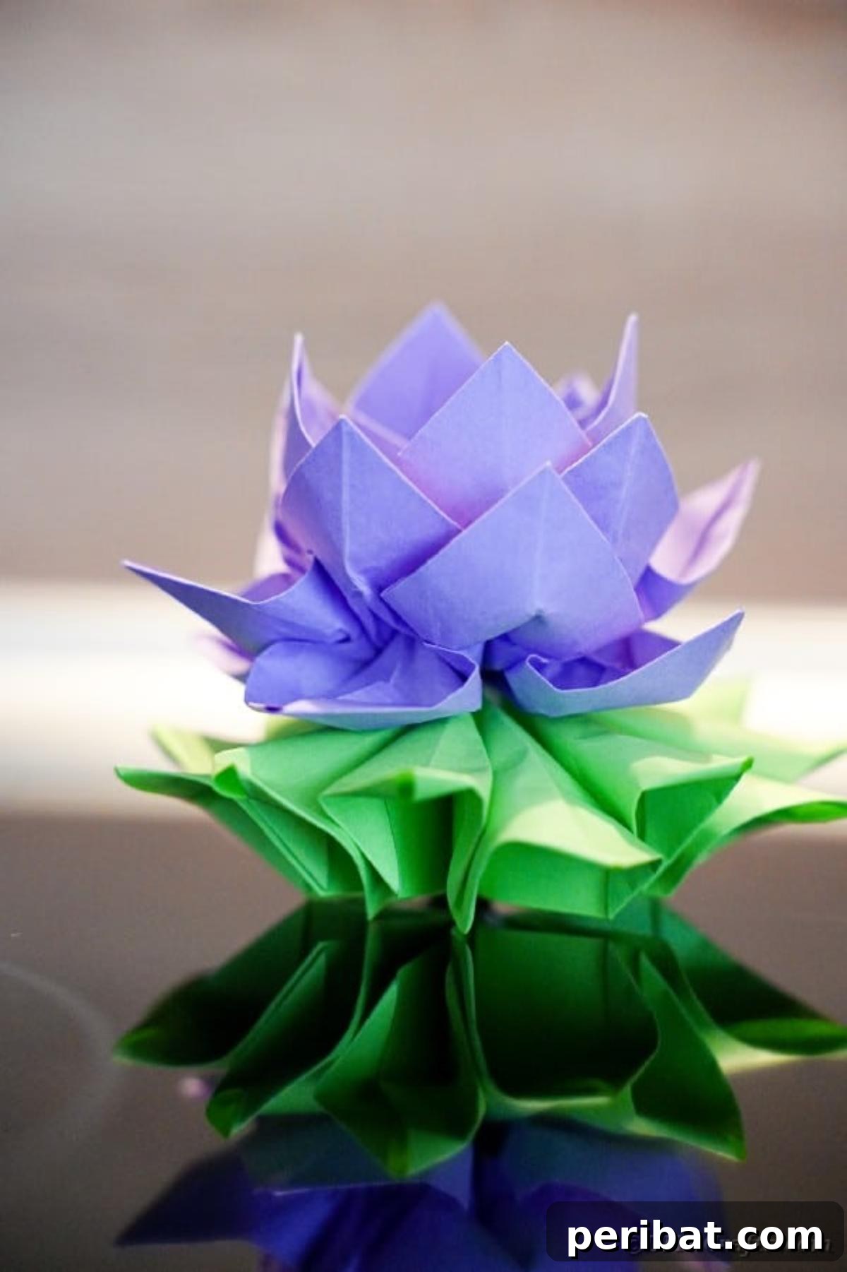 A striking purple paper lotus rests elegantly on a black table, ready for display.