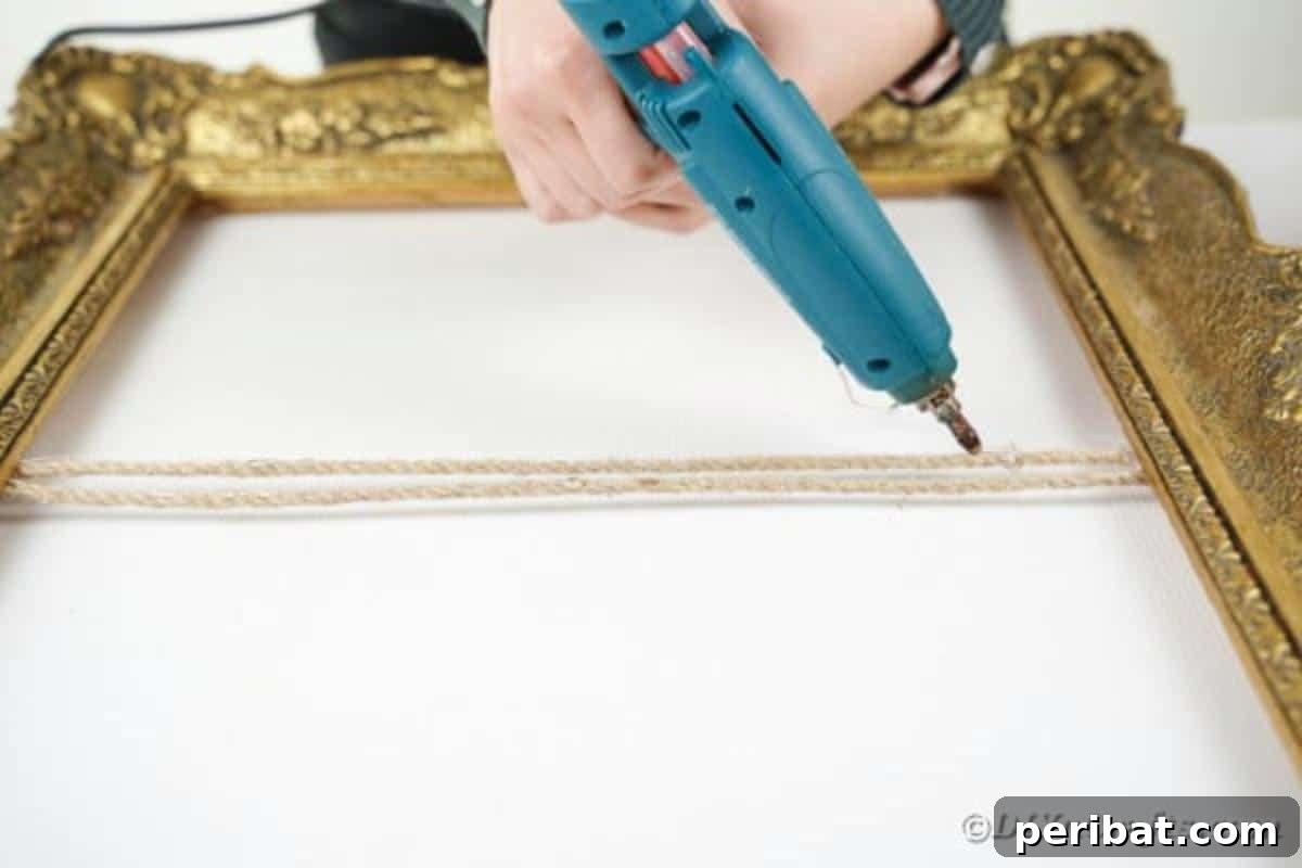 Hot glue applied to the front-facing sections of the twine on the ornate frame, ready for the flower attachment
