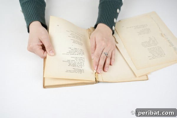 Woman tearing pages from an old book