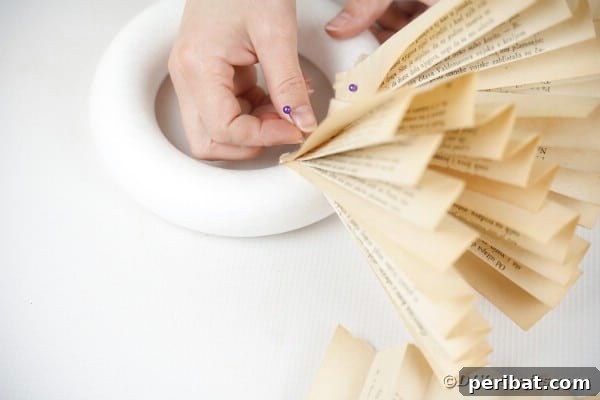 Woman attaching paper fans to wreath form