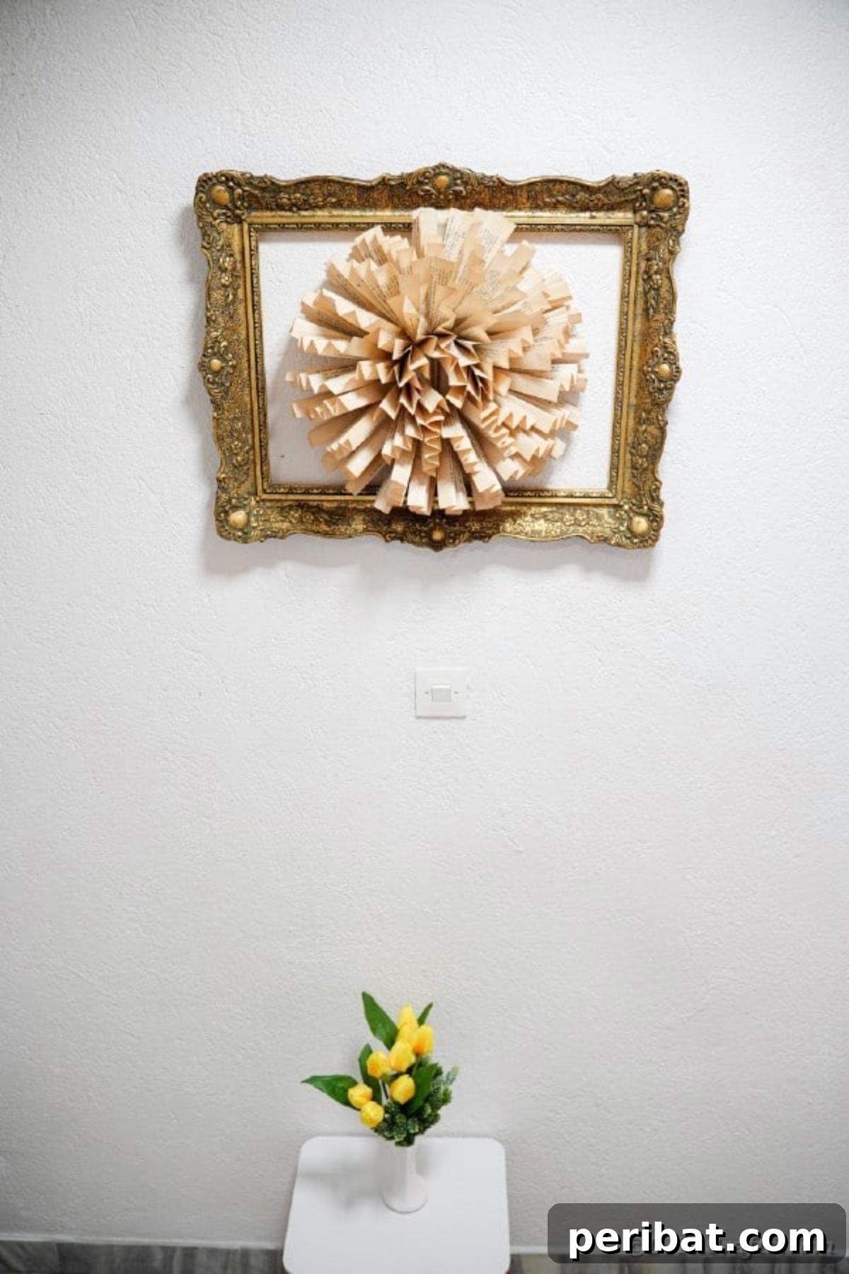 Finished paper flower wall art made from old book pages, hanging elegantly on a wall